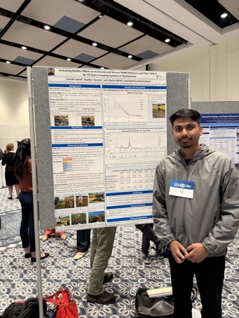 Saurab standing beside his poster on biochar, nitrogen emissions, and corn yield