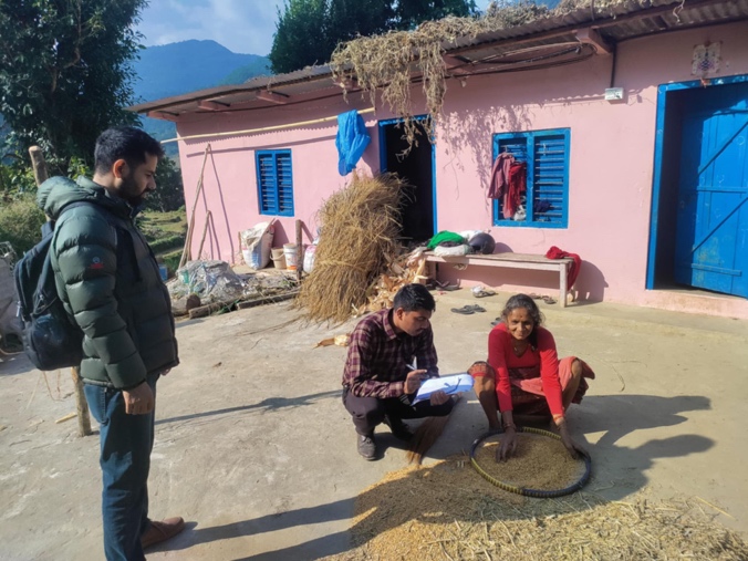 An agricultural field visit with community members outside a home in Rupa